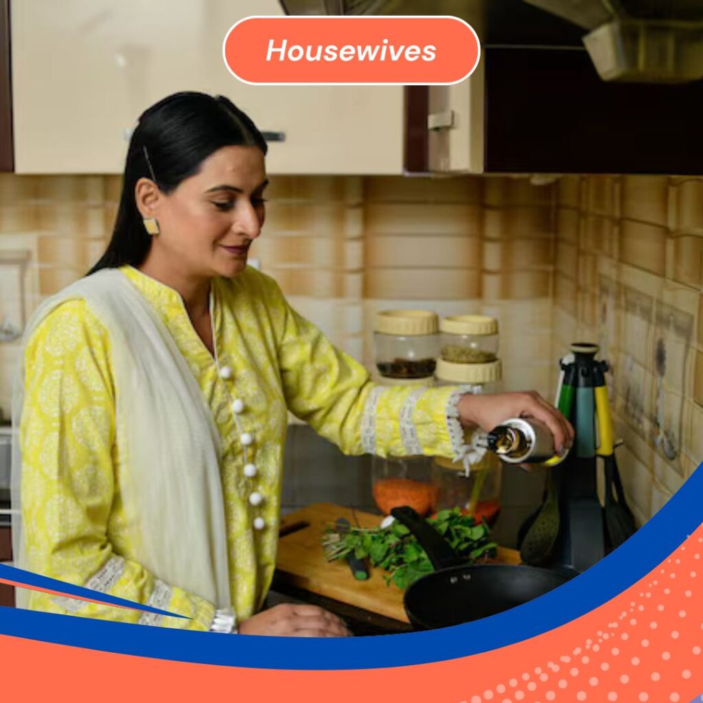 Indian housewife cooking in a modern kitchen, pouring oil into a pan with fresh vegetables nearby.