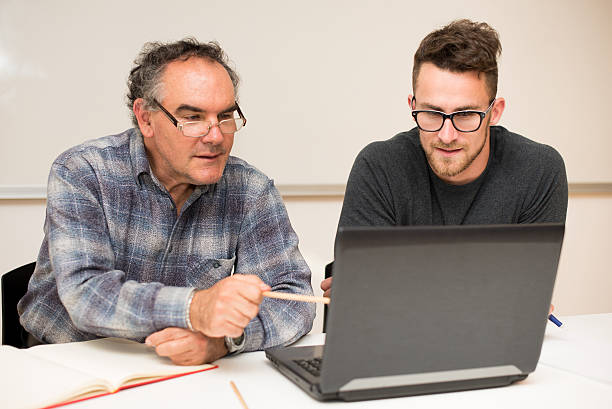 An experienced instructor guiding a young student on a laptop—demonstrating HIDM’s expert faculty support in digital marketing education, offering in-depth mentorship in SEO, Google Ads, social media marketing, and performance marketing strategies.