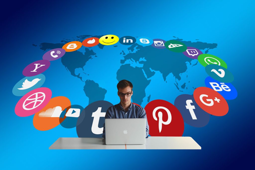 A person working on a laptop with various social media icons surrounding a world map—representing HIDM’s Social Media Marketing (SMM) training, including Facebook, Instagram, LinkedIn, Twitter marketing, content strategy, paid campaigns, and audience engagement techniques.