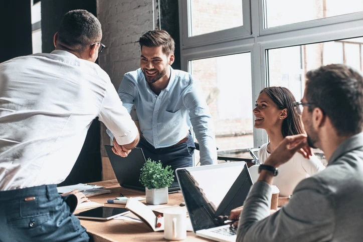 "E-commerce marketing specialist at HiDM collaborating with team members, discussing online sales strategies and digital business growth in a modern office meeting."
