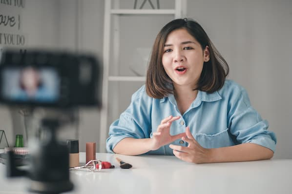 "YouTube content creator and influencer marketing specialist from HiDM recording a video with makeup products, building personal brand and digital audience engagement."