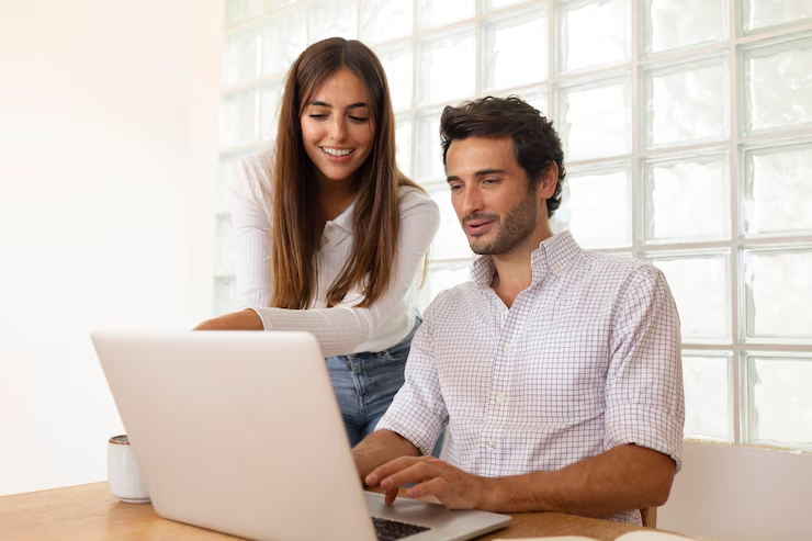 "Social media manager from HiDM working on a laptop with a colleague, planning online campaigns and managing digital brand presence."