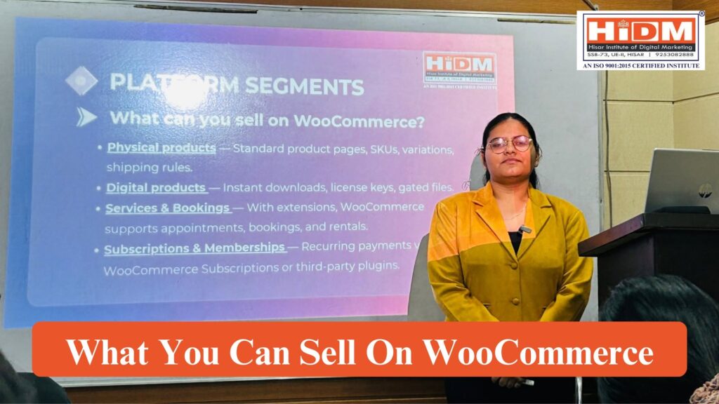 A seminar presentation at HiDM (Hisar Institute of Digital Marketing) showing a speaker standing beside a projected slide titled "Platform Segments – What Can You Sell on WooCommerce?" The slide explains different product categories including physical products, digital products, services and bookings, and subscriptions or memberships. A podium with a laptop is visible, and the image features HiDM branding with the heading "What You Can Sell On WooCommerce."