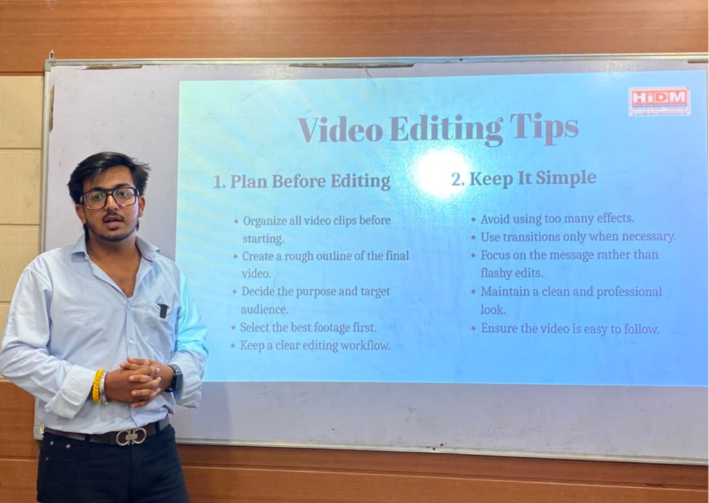 Goutam delivering a seminar on video editing tips at HiDM while explaining planning before editing and keeping video edits simple using a presentation screen.