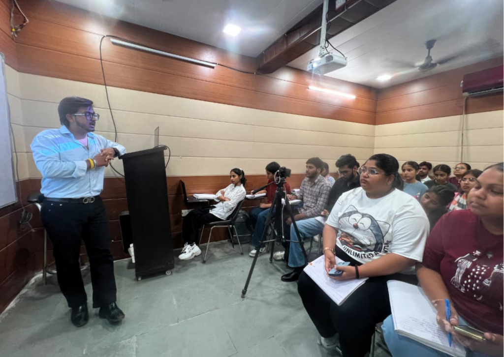 Goutam presenting a live seminar on VN AI Editor while students attentively listen and take notes in a classroom at HiDM.