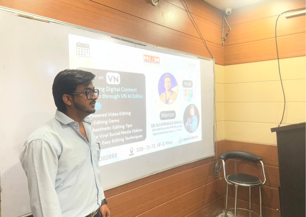 Side profile of Goutam presenting the VN AI Editor seminar beside a projected presentation screen at HiDM.