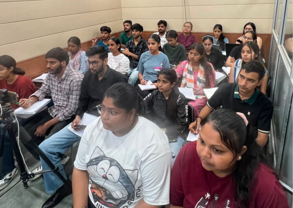 Students attentively attending a video editing seminar at HiDM while taking notes and listening to the presentation.